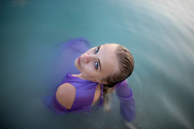 Foto chica en vestido ajustado se baña en el lago