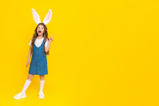 Una chica con un vestido azul con orejas de conejo en un fondo amarillo