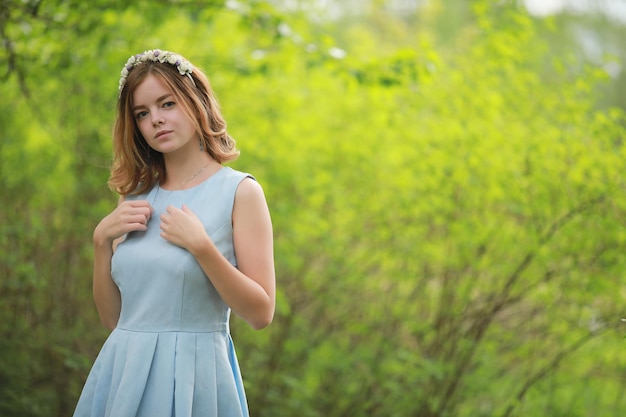 Chica en vestido azul en parque verde