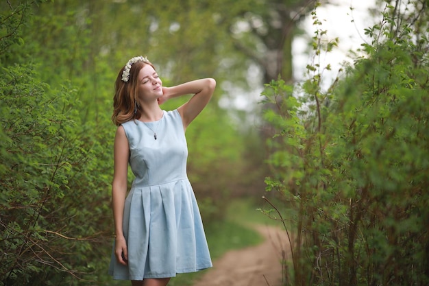 Chica en vestido azul en verde verano parkxA