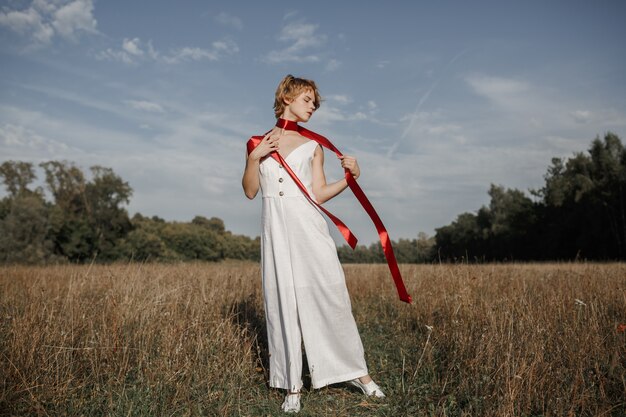 Chica con un vestido blanco con una cinta roja