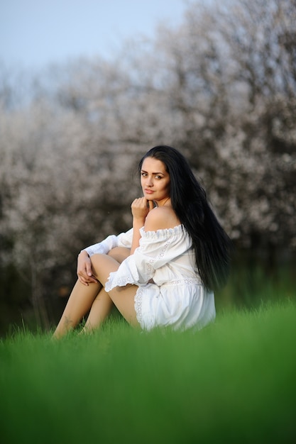 Chica en vestido blanco sobre la hierba