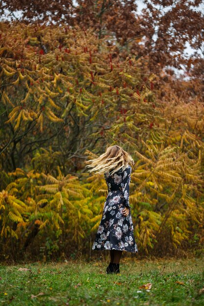 Chica con un vestido en el bosque de otoño