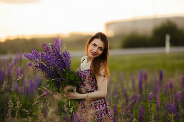 Chica con un vestido de color. Sostiene flores en sus manos