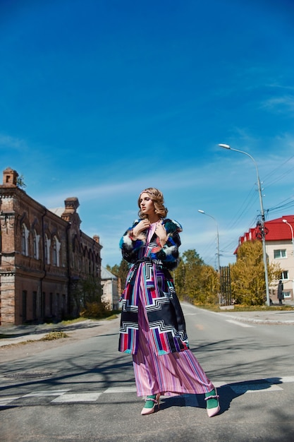 Chica en un vestido hecho a mano de moda étnica vintage posando al aire libre. Traje retro inusual en el cuerpo de la niña, sonrisa y emociones alegres. Rusia, Sverdlovsk, 10 de junio de 2019