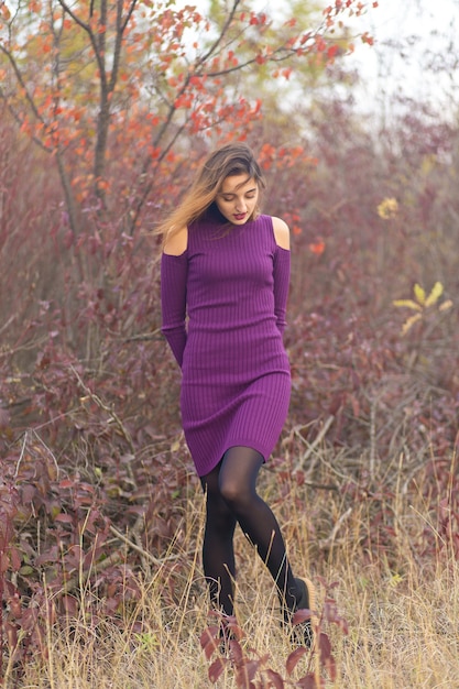 Chica en vestido lila en la naturaleza en otoño, Retrato de una chica hermosa en el otoño en el bosque