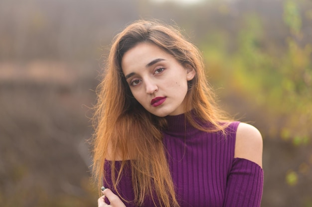 Chica en vestido lila en la naturaleza en otoño Retrato de una hermosa niña en el otoño en el bosque