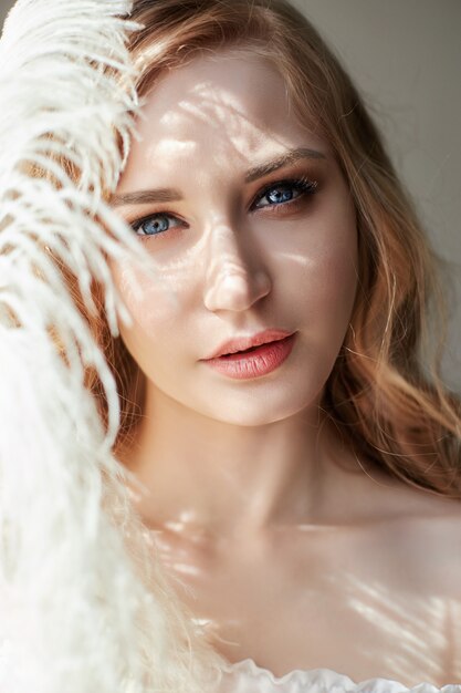 Chica en vestido de luz blanca y pelo rizado.