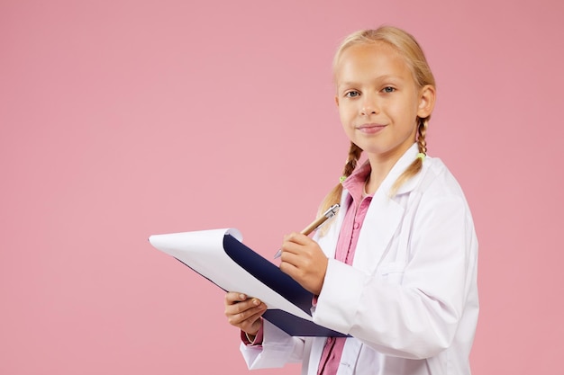 Chica en vestido de médicos haciendo notas