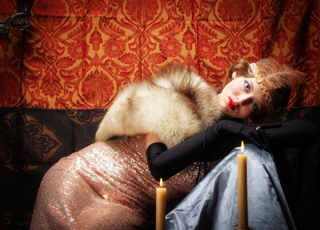 Chica con un vestido de noche con una boa. Estudio de fotografía de estilo retro