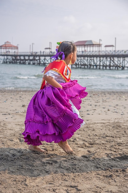 Foto una chica con un vestido púrpura está corriendo por la playa