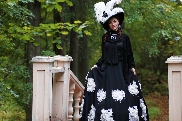 Chica en vestido retro antiguo en las escaleras al aire libre