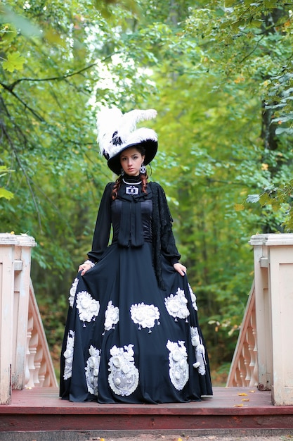 Chica en vestido retro antiguo en las escaleras al aire libre