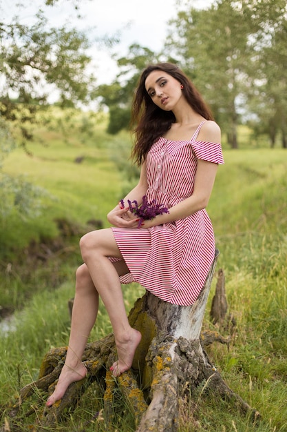 Chica en vestido rojo en la naturaleza en verano Retrato de una chica hermosa en el verano en el bosque