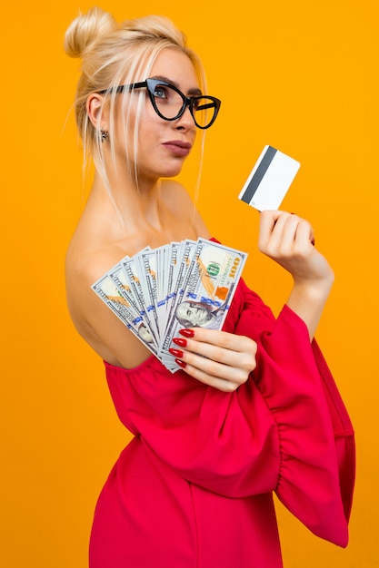 Chica con un vestido rojo con una pila de dinero y una tarjeta