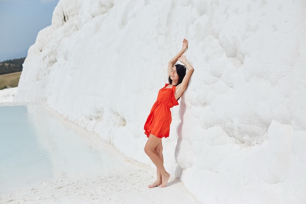 Chica en vestido rojo sobre travertinos blancos, Pamukkale