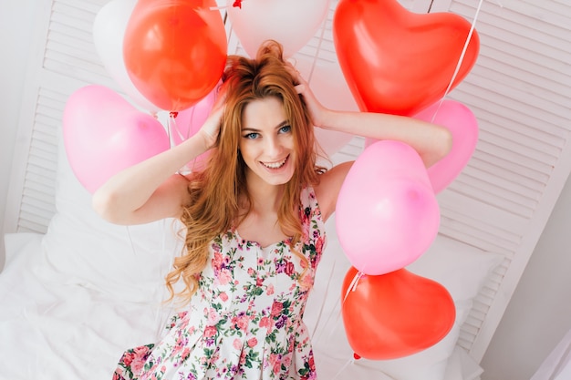 Chica en vestido romántico con globos en forma de corazón