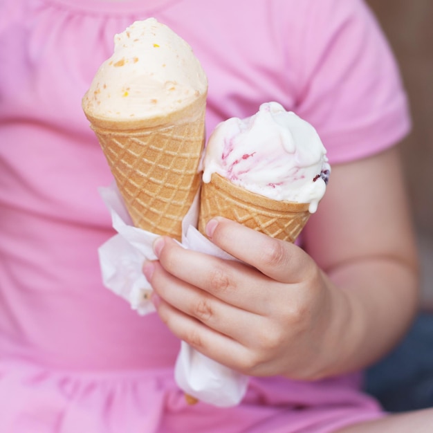 Chica en vestido rosa comiendo helado en climas cálidos