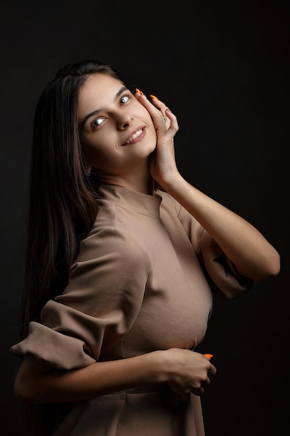 una chica en un vestido sobre un fondo marrón