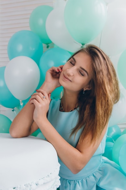 Chica en vestido turquesa con globos