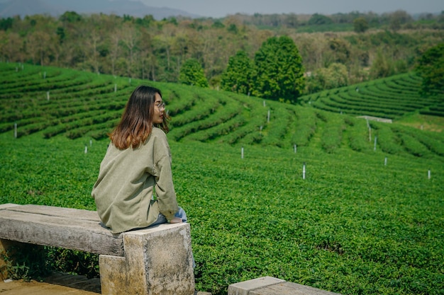 chica de viaje mirando la vista del campo de té.