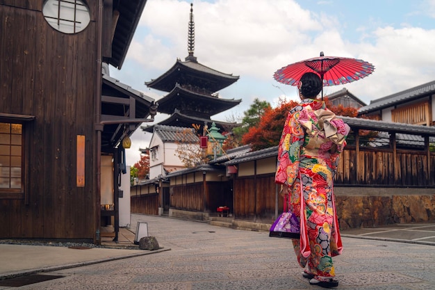 Chica viajera asiática con traje tradicional kimono caminando en el antiguo templo de la ciudad de Kioto, Japón