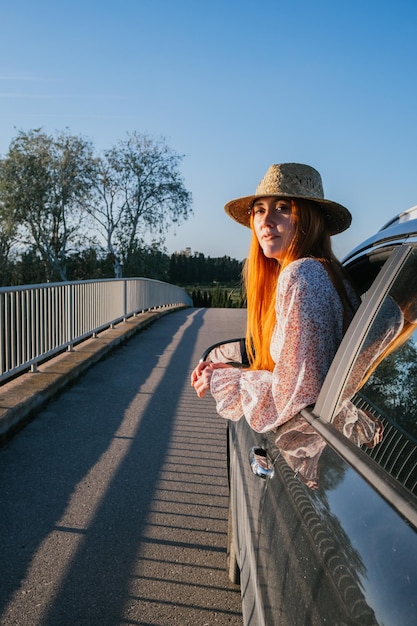 Chica viajera asomándose por la ventana del auto