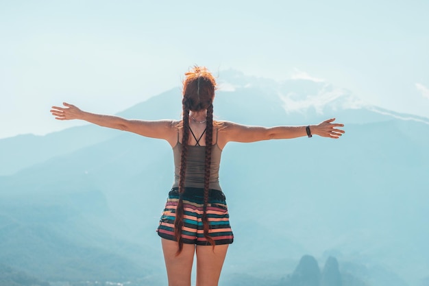 Chica viajera feliz parada en la cima de la colina con vista al monte Tahtali en Turquía Destinos y atracciones turísticas