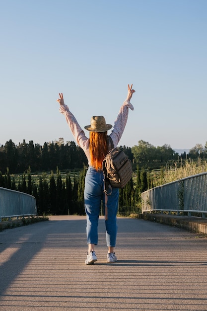 Chica viajera levantando los brazos