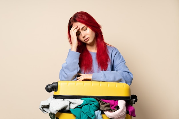 Chica viajera con una maleta llena de ropa