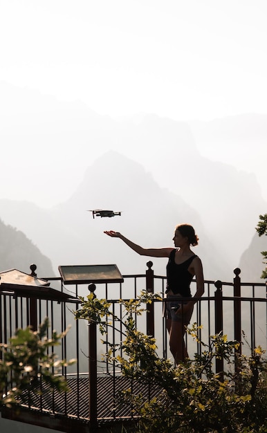 Foto chica viajera sola volando un dron