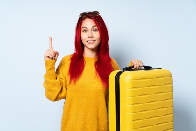 Chica viajera sosteniendo una maleta