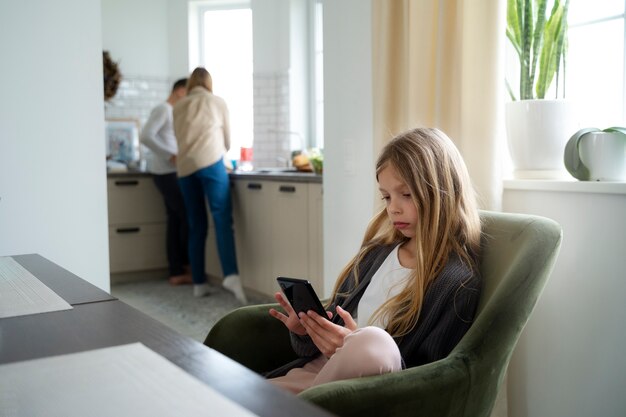 Foto chica de vista lateral con teléfono inteligente