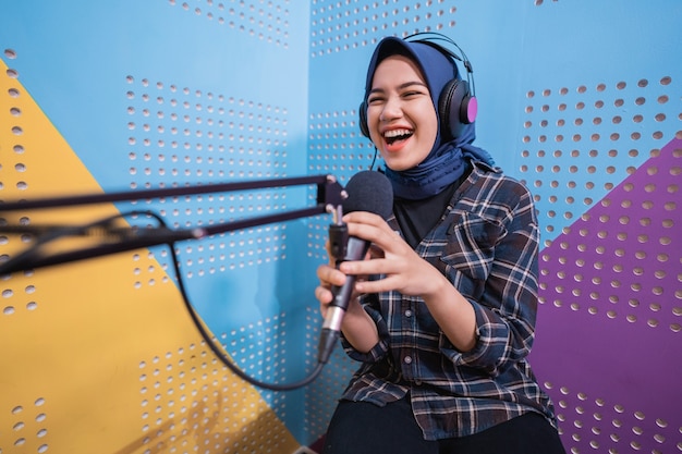 Una chica vlogger está grabando un podcast en el estudio.