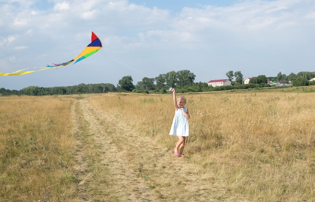 Chica volando una cometa en verano