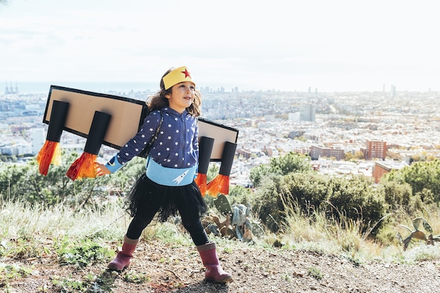 Chica volando disfrazada de superhéroe con disfraz