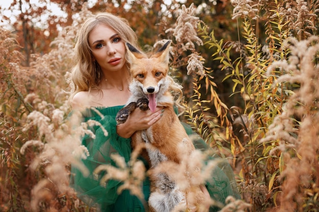 Chica con zorro rojo en otoño