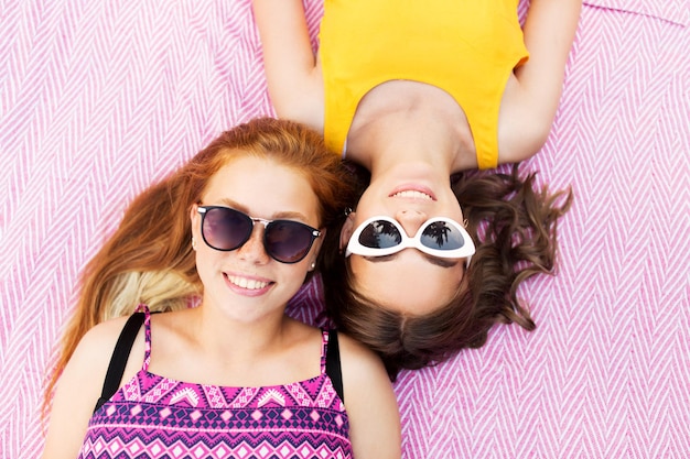 Foto chicas adolescentes con gafas de sol en una manta de picnic