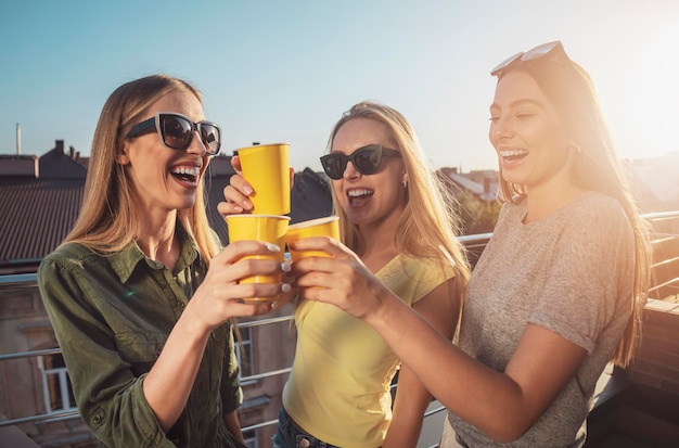 Chicas alegres con gafas de sol tocando gafas