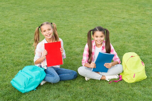 Las chicas de las amigas de la escuela estudian al aire libre haciendo el concepto de tarea