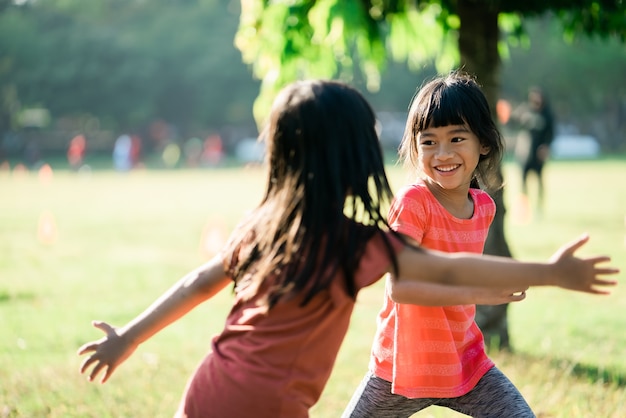 Chicas asiáticas están jugando en el parque por la mañana