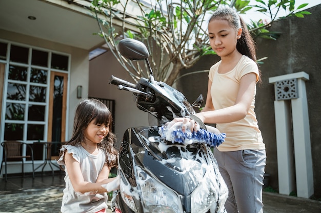 Chicas asiáticas lavando una motocicleta