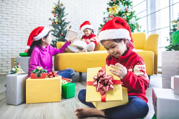 chicas asiáticas sorprenden con un regalo y ayudan a decorar juntas para celebrar en el festival de Navidad