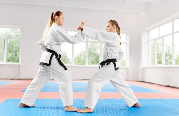 chicas atléticas que luchan utilizando técnicas de karate en la clase de karate ligero.