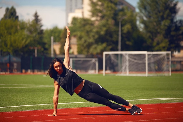 Las chicas de atletismo en el estadio hacen ejercicios.