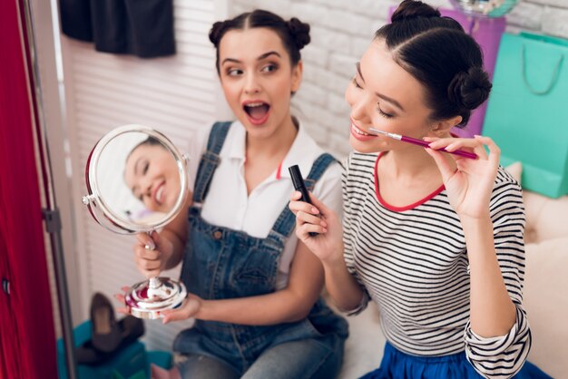 Foto las chicas bloggers sostienen la máscara y el espejo frente a la cámara.