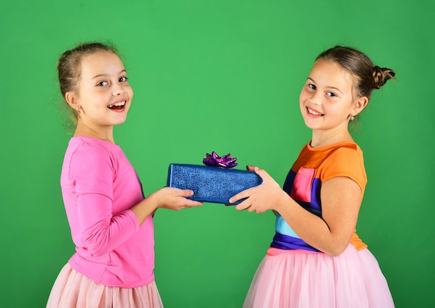 Chicas con caras felices posan con regalos sobre fondo verde