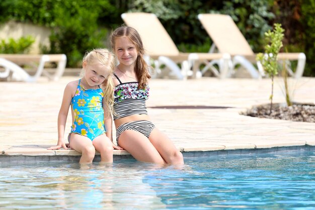 Chicas cerca de la piscina al aire libre