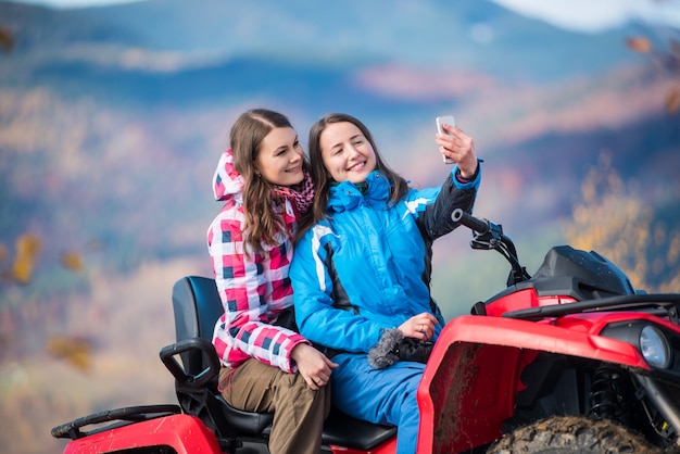 chicas en chaquetas de invierno en rojo ATV