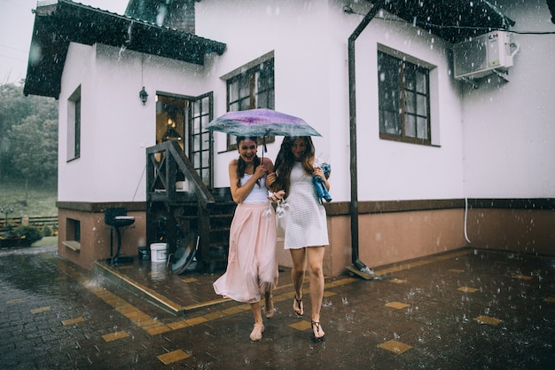 Chicas corriendo de la lluvia